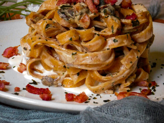 Tagliolini al peperoncino con funghi, cipolle rosse e pancetta croccante alla panna